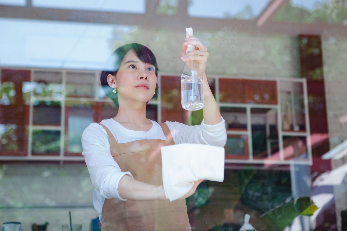 A cleaning operative wiping a glass partition in a modern workplace